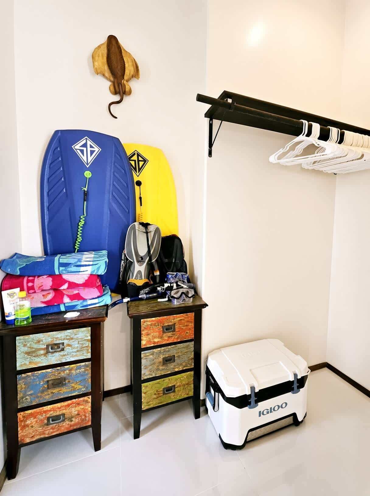 Une pièce comprenant un lit, un bureau avec une chaise, un porte-manteau fixé au mur et un meuble de rangement.