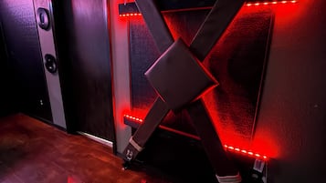 A room with a red-lit structure, a door, and a wall with a motivational quote.