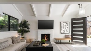 A modern living room with a fireplace, a large window, and a minimalist design.
