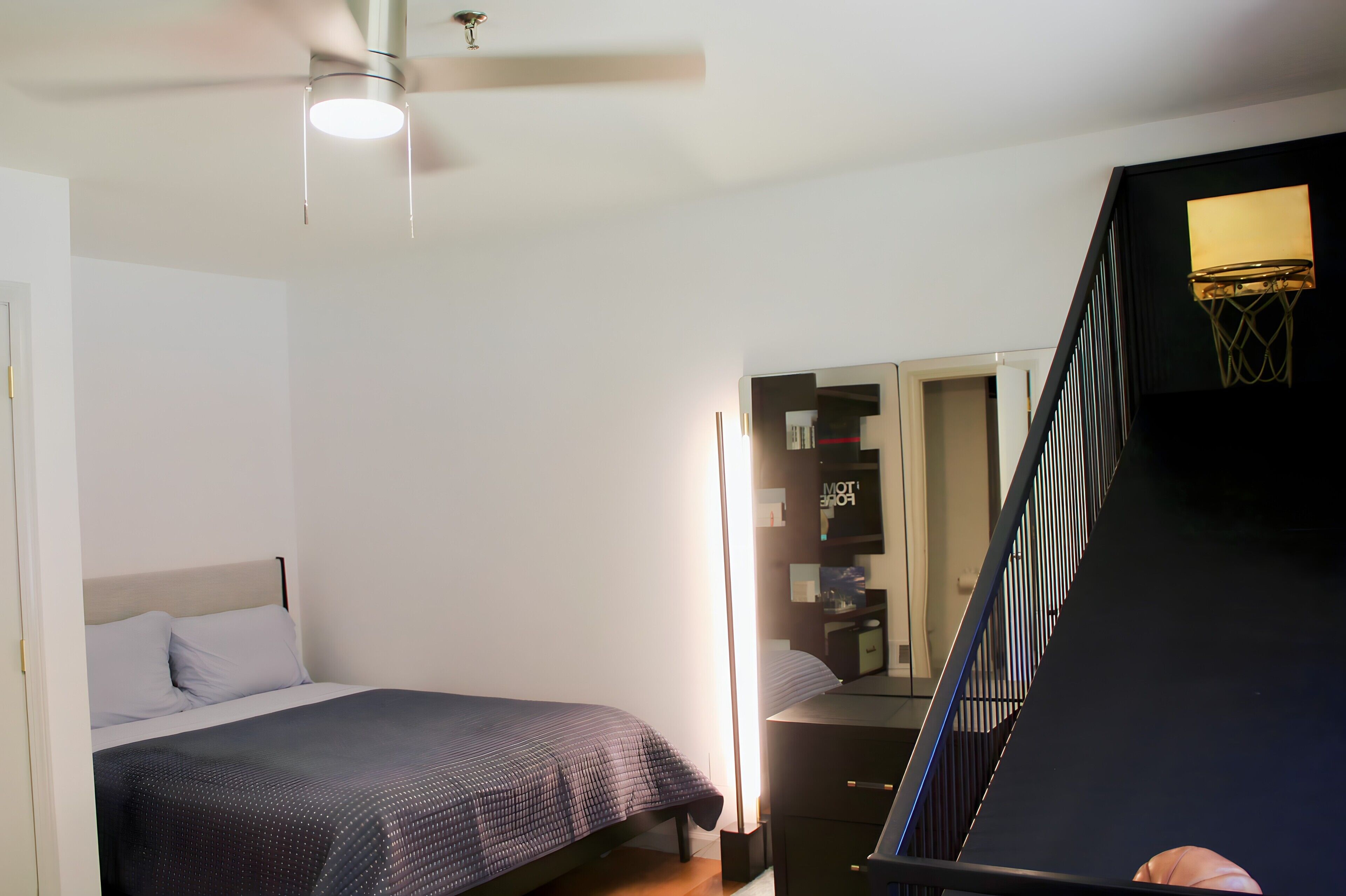 Un dormitorio con cama, cómoda, espejo y armario.