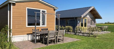 A wooden cabin with a patio and a small garden.