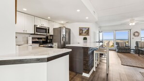 Een moderne keuken met witte kasten, roestvrijstalen apparatuur en een groot eiland.