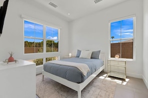 A bedroom with a bed, bedside tables, and a window with a view. - Mountain Paradise: Pool & Spa Retreat (La Quinta)
