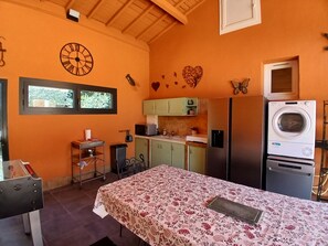 Een kleine keuken met een wasmachine, een klok en een raam.
