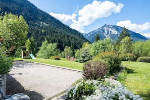 A mountain landscape with a playground and a gravel area.