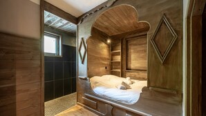 Une pièce en bois avec un lit, une fenêtre et un espace douche.