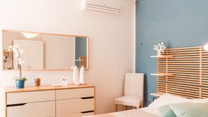 Un dormitorio con cama, cómoda, silla, espejo y mesita de noche.