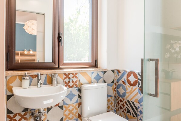 Un baño con lavamanos, inodoro y ventana.