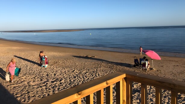 A beach with a wooden deck, clear skies, and calm water. - Chalet El Paraíso with sea views, private terrace, and Wi-Fi (Laguna del Portil/Huelva)