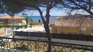 A coastal view with a building featuring a tiled roof, a fenced area, and a tree in the foreground. - Chalet El Paraíso with sea views, private terrace, and Wi-Fi (Laguna del Portil/Huelva)