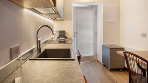A compact kitchen with a sink, stove, and overhead ventilation. - Holiday Home 'Rosso' with Mountain View, Wi-Fi and Air Conditioning (Albosaggia)