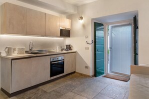 Eine moderne Küche mit integrierten Geräten, einer Spüle und einer Tür zum Balkon.
