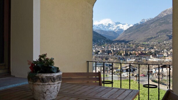 Een balkon met uitzicht op een stad en bergen.