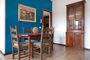 Un comedor con una mesa de madera, sillas y un armario.