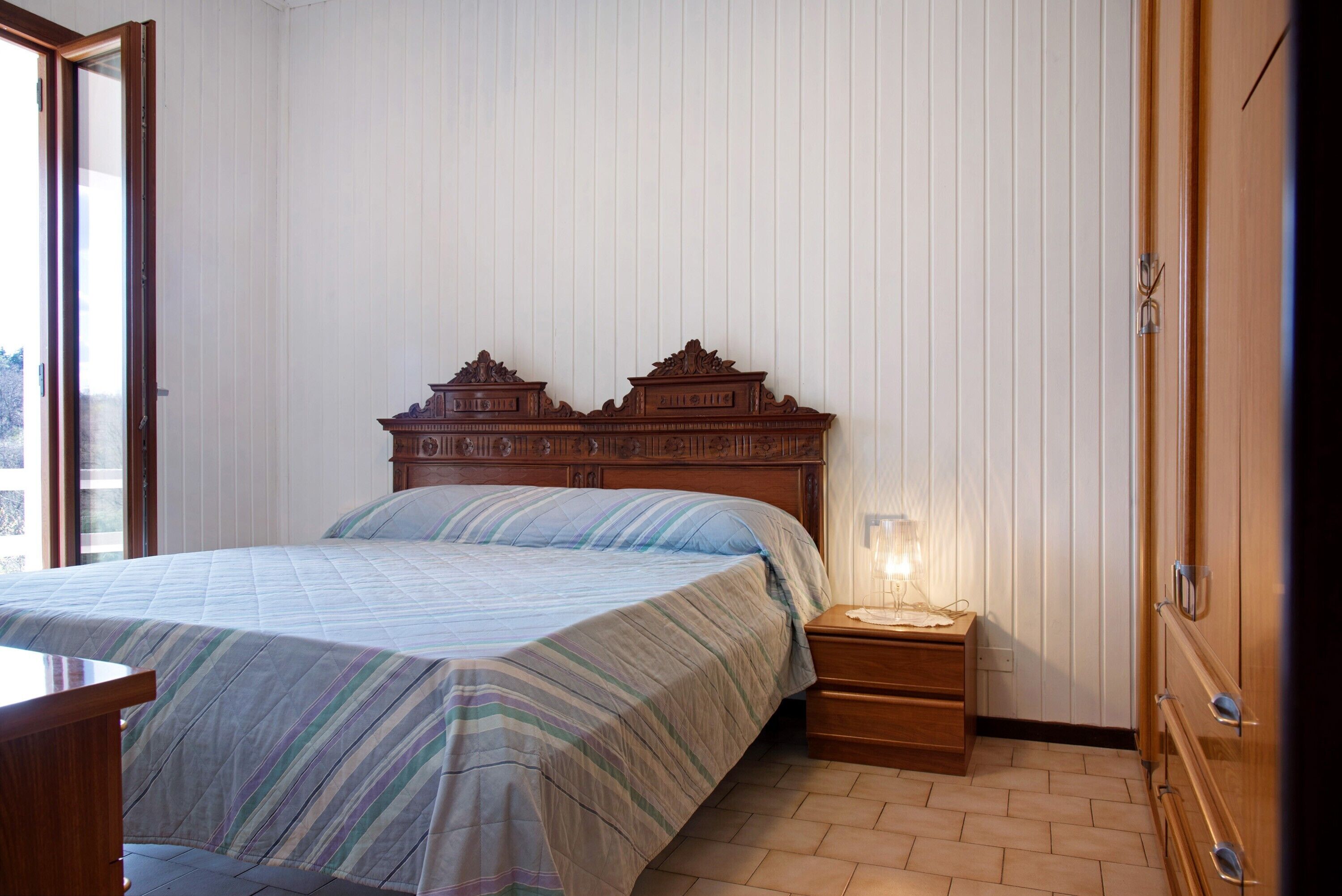 Une chambre à coucher avec un lit en bois, une table de chevet et une commode.
