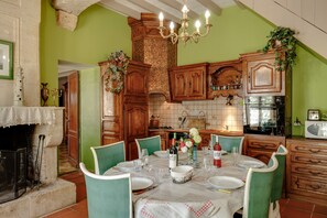Un comedor con una mesa dispuesta para cuatro personas, rodeado de armarios de madera y un salpicadero de azulejos.