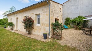 A stone building with a gravel patio and outdoor furniture.