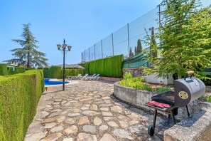 A stone patio with a pool, a barbecue grill, and lounge chairs. - Villa 'Leonor Con Piscina Privada' with Mountain View, Wi-Fi and Air Conditioning (Monachil)