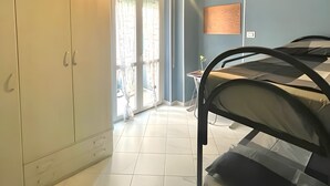 Una habitación con cama, armario y candelabro.