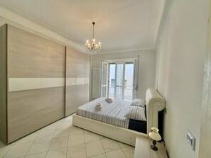 Um quarto com cama, um candelabro, uma porta de correr e vista pela porta.