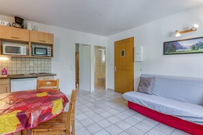 Ein gemütlicher Wohnbereich mit Küchenzeile, Essplatz und einer Couch.