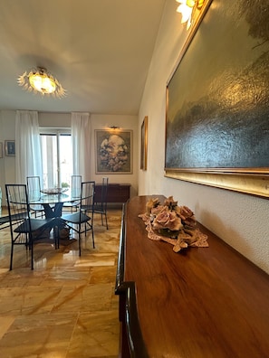 Un comedor con una mesa de madera, sillas y un cuadro en la pared.