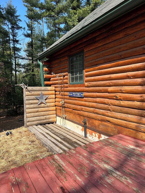 A log cabin with a star-shaped door, a window, and a sign reading "Wolverine's Ave." - House in the woods perfect vacation rental for those to escape (Adams)