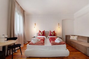 Une chambre d’hôtel avec un lit, un canapé, une table à manger et une chaise.