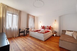 A bedroom with a bed, a sofa, a desk, and a chair. - Room 'King Suite' with Mountain View and Wi-Fi (Merano)