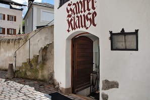 Un bâtiment avec une porte en bois et une enseigne au-dessus.