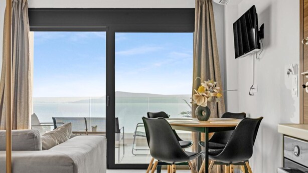 A modern room with a large sliding glass door leading to a balcony with a view of the sea. - Apartment 'Oceanida' with Sea View, Wi-Fi and Air Conditioning (Nikiana)
