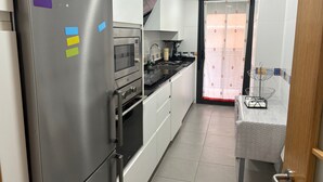 Une cuisine moderne équipée d’appareils électroménagers en acier inoxydable, d’un four à micro-ondes et d’un évier.