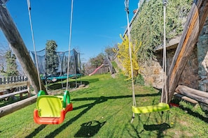Une aire de jeux avec des balançoires et un toboggan.