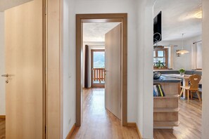 Un pasillo con suelo de madera que conduce a un balcón con vistas.