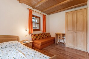 Un dormitorio con cama, sofá, escritorio y armario.