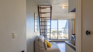 A room with a bed, a ladder, and a view of the sea. - Apartment 'Ty Fox By Madame Est Servie' with Sea View and Balcony (Perros-Guirec)