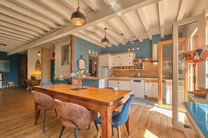 A spacious kitchen with wooden cabinets, a dining table, and blue chairs. - Holiday Home 'Saint Vincent De Mercuze Casavilla' with Mountain View, Private Pool and Wi-Fi (Saint-Vincent-de-Mercuze)