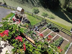 A garden with raised beds, a wooden structure, and a wooden fence. - Apartment 'Lü Da Plazores Falc' with Mountain View, Shared Garden and Wi-Fi (Marebbe)