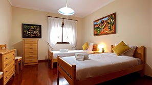 A bedroom with two beds, a wooden dresser, a painting, and a ceiling light. - Apartment 'Ocean and River' with Wi-Fi (Torreira)