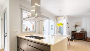 Una cucina moderna con un'isola grande, forno integrato e finestra con vista su un giardino.