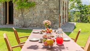 A table set outdoors with fruits, a pitcher of red drink, and a vase of flowers. - Holiday Home 'Rustico Con Jacuzzi In Toscana' with Shared Pool, Wi-Fi and Air Conditioning (Colle di Val d'Elsa)