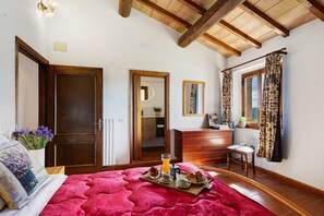 A bedroom with a wooden ceiling, a bed with a red blanket, a breakfast tray, and a wooden dresser. - Holiday Home 'Toscana' with Shared Pool, Private Garden and Wi-Fi (Colle di Val d'Elsa)