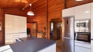 Una cocina moderna con paredes de madera, electrodomésticos de acero inoxidable y una isla central.