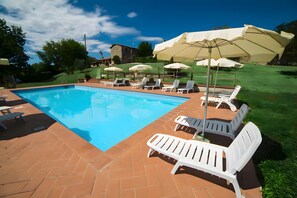 A swimming pool with lounge chairs and umbrellas. - Cottage 'Rustico Toscano' with Shared Pool, Shared Garden and Wi-Fi (Colle di Val d'Elsa)