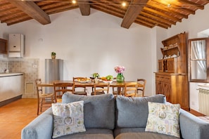Uma sala de estar aconchegante com um sofá, mesa de jantar de madeira e cadeiras.