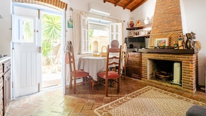 Un comedor con mesa y sillas, chimenea y vistas al exterior.