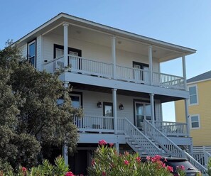 A two-story building with a balcony and a staircase leading to the upper floor.