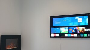A modern room with a flat-screen TV mounted on the wall displaying a streaming service interface. - European Apartment in New Plymouth Central (New Plymouth)