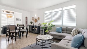 A modern living room with a sofa, dining table, chairs, and a coffee table. - Luquillo Family Home | Sleeps 10 | Near Beach (Juan Martín)