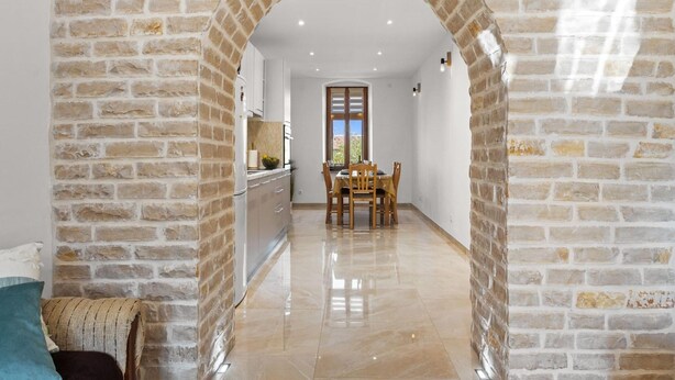 A hallway with a brick archway leading to a dining area with a table and chairs. - Apartment in Vodnjan With Pool & Jacuzzi (Vodnjan)
